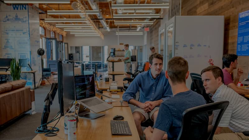 Engineers working together at a bank of monitors in a studio office